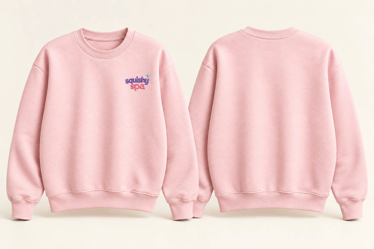 AI concept illustration of the pink adult crewneck sweatshirt, with a small Squishy Spa wordmark and aqua star on the left chest, and a blank back